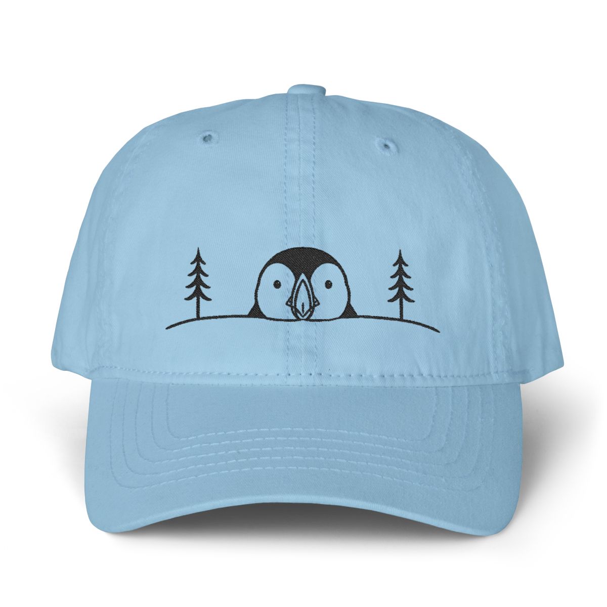 Cashmere blue cotton dad hat with a minimalist black embroidered puffin between pine trees